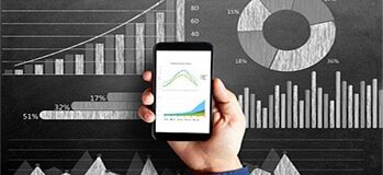 Businessman's hand holding smart phone with a diagram of business strategy drawn on blackboard that represents the concepts of business growth.