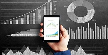 Businessman's hand holding smart phone with a diagram of business strategy drawn on blackboard that represents the concepts of business growth.